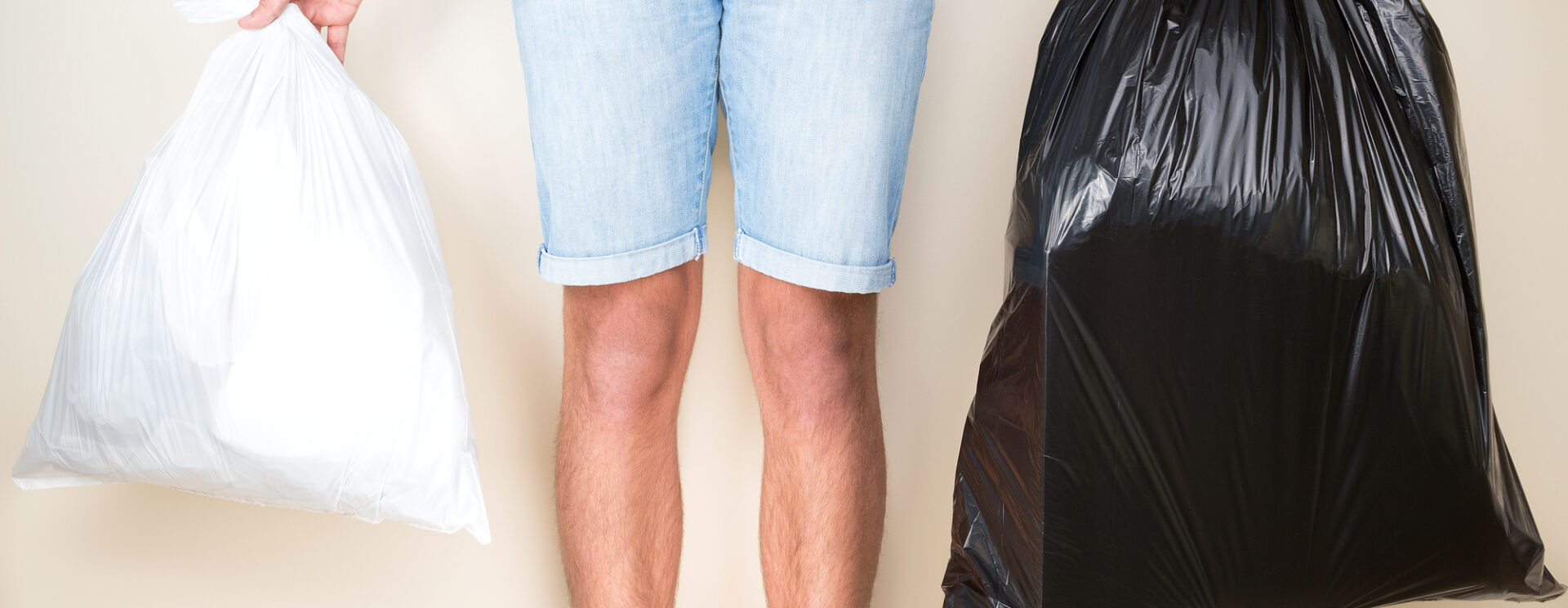 Individu qui tient deux sacs poubelles dans les mains