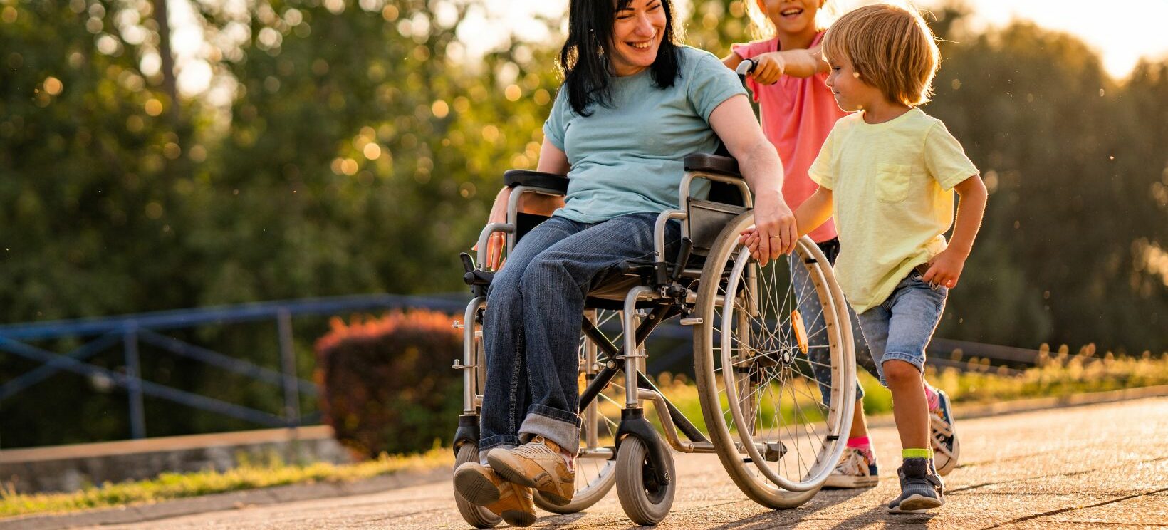 Personne en fauteuil roulant accompagnée de deux enfans