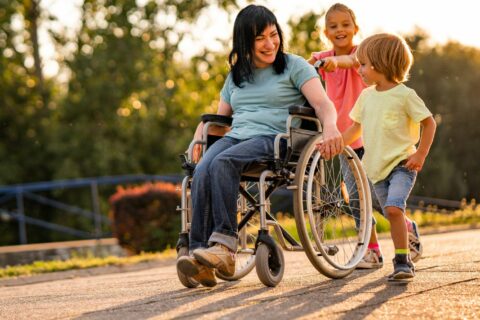 Personne en fauteuil roulant accompagnée de deux enfans