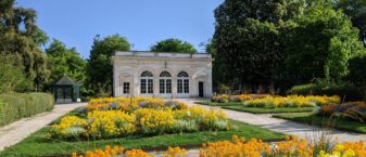 Vue de l'Orangerie dans la jardin public avec des parterres de fleurs orange et jaune