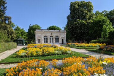 Vue de l'Orangerie dans la jardin public avec des parterres de fleurs orange et jaune