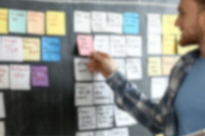 Jeune qui recherche un job en consultant des post-it. - Agrandir l'image, fenêtre modale