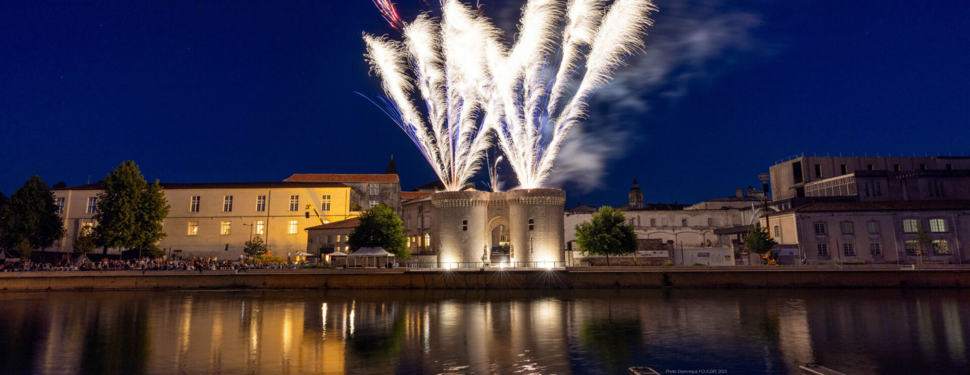 Quais de Cognac de nuit avec la porte Saint-Jacques éclairée d'un feu d'artifice